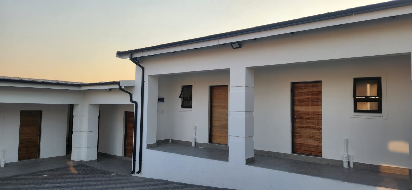 Completed charcoal gutter and downpipe installation across a residential property